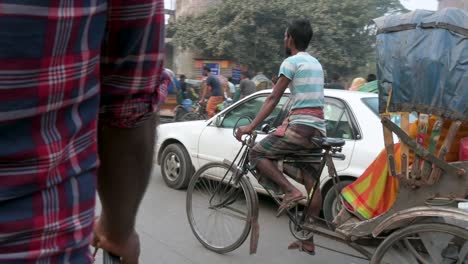 Blick-Aus-Der-Ersten-Person-Von-Einem-Rikscha-Beifahrersitz-Aus,-Während-Ein-Rikscha-Fahrer-Durch-Die-Verstopften-Straßen-Von-Dhaka-Fährt