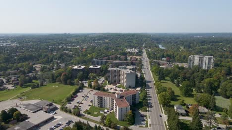 Drone-shot-flying-a-long-a-road-in-London,-Ontario-on-a-hazy-day-in-summer