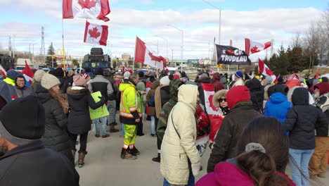 Crowds-of-people-gathered-for-the-freedom-convoy-in-Windsor-Canada-and-the-police-welcome-them-with-armored-vehicles