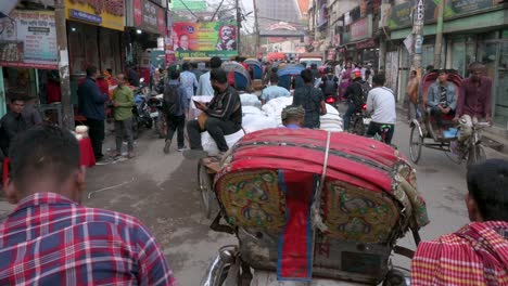 Blick-Aus-Der-Ersten-Person-Von-Einem-Rikscha-Beifahrersitz-Aus,-Während-Ein-Rikscha-Fahrer-Durch-Die-Belebten-Straßen-Von-Dhaka-Fährt