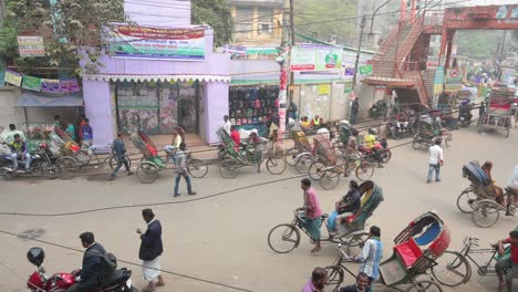 Escena-De-La-Vida-Cotidiana-De-Una-Calle-Muy-Transitada-Que-Muestra-Numerosos-Rickshaws-Y-Tiradores-De-Rickshaw-En-Dhaka,-Bangladesh