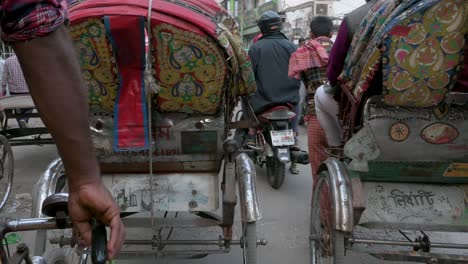 Blick-Aus-Der-Ersten-Person-Von-Einem-Rikscha-Beifahrersitz-Aus,-Während-Ein-Rikscha-Fahrer-Durch-Die-Hektischen-Straßen-Von-Dhaka-Fährt