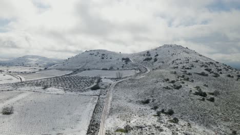 Drohnenaufstieg-Aus-Der-Luft-Auf-Den-Schneebedeckten-Berg-Shifon-Und-Die-Weinberge,-Israel