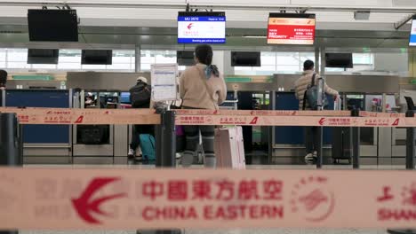 Flight-travel-passengers-check-in-at-the-Chinese-flag-carrier-China-Eastern-airline-desk-counter-at-Chek-Lap-Kok-International-Airport-in-Hong-Kong