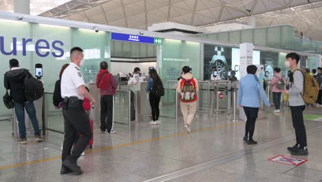 Flugpassagiere-Stehen-Schlange,-Um-Die-Sicherheitskontrolle-In-Der-Abflughalle-Des-Internationalen-Flughafens-Chek-Lap-Kok-In-Hongkong,-China,-Zu-Durchlaufen