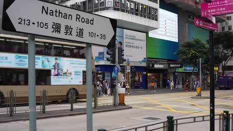 Nathan-Road-intersection,-pedestrians-walking-and-cars-driving