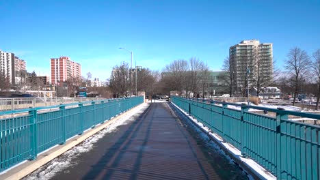 Walking-over-snowy-bridge-in-downtown-Mississauga-in-winter