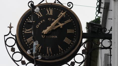 Static-shot-of-Western-Union-clock-black-and-gold-wrought-iron,-minute-hand-moving