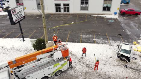 Repair-crew-repairs-downed-power-lines,-snow-on-the-ground