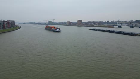 Aerial-Flying-Towards-Approaching-Scaldis-Container-Ship-Travelling-Along-Oude-Maas-On-Overcast-Day-In-Dordrecht