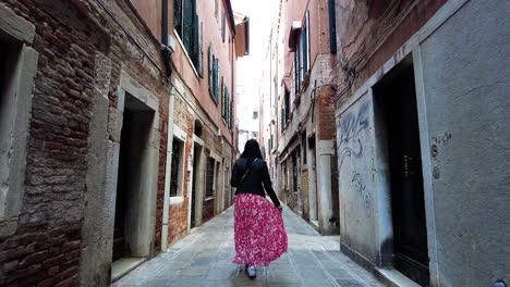 Following-A-Woman-Tourist-Walking-Through-Narrow-Alleys-In-Venice,-Italy