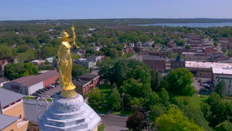 Fly-past-the-gold-Statue-of-Lady-Justice-on-top-of-the-Beautiful-Ontario-County-Courthouse-in-Canandaigua,-New-York-near-Canandaigua-Lake