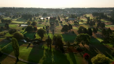 Wide-aerial-view-of-a-well-maintained-golf-course-at-sunrise-in-Oak-Harbor,-Washington
