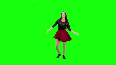 Young-energetic-brunette-female-dancing-sensually-against-green-screen-background