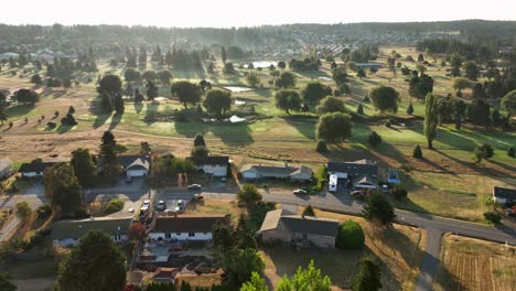 Wide-aerial-view-of-homes-surrounding-a-golf-course-at-sunrise