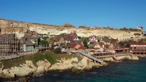 Wooden-Houses-At-Theme-Park-Village-At-Popeye-In-Anchor-Bay,-Island-Of-Malta