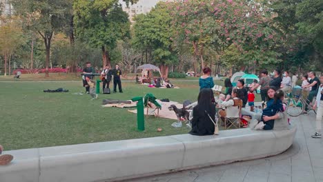 Locals-enjoy-afternoon-and-listen-to-live-band-music-in-Linjiang-Linear-Park,-Guangzhou
