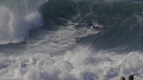 Surfer-riding-huge-ocean-wave-in-Nazare,-Portugal,-surfing-is-dangerous-extreme-sport