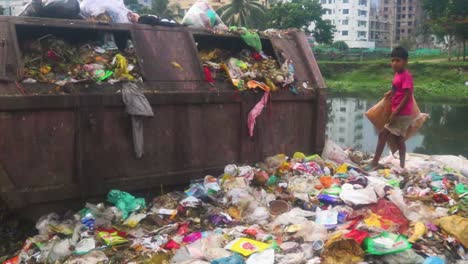 Ein-Kinderarbeiter-Durchwühlt-Den-Müll-Auf-Einer-Mülldeponie-In-Dhaka,-Bangladesch,-Und-Sucht-Als-Lumpensammler-Nach-Wertstoffen