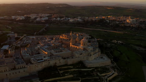 Sunset-Over-Ancient-Medieval-Walled-City-Of-Mdina-In-Malta---aerial-drone-shot