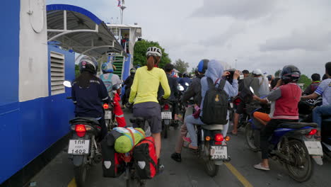 Asian-people-on-motorcycles-and-bicycles-exiting-the-ferry-boat,-Songkhla-ferry,-Thailand