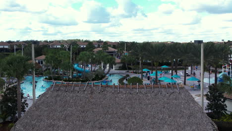 Ascending-aerial-view-of-people-at-a-pool-area-at-the-Champions-Gate-resort,-in-Orlando,-Florida,-USA