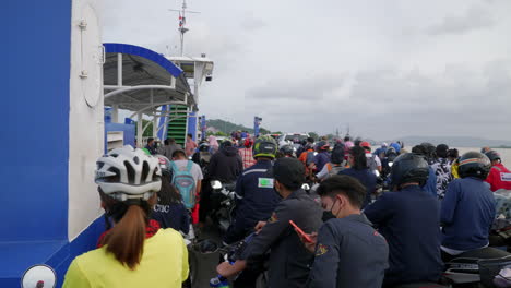 People-on-motorcycles-and-bicycles-riding-on-ferry-boat,-Songkhla-ferry,-Thailand