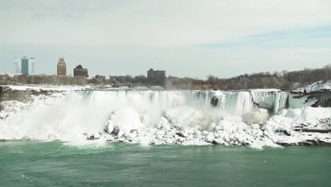 Wide-static-view-of-Niagara-Falls,-icy-cliffs-and-snow-in-winter