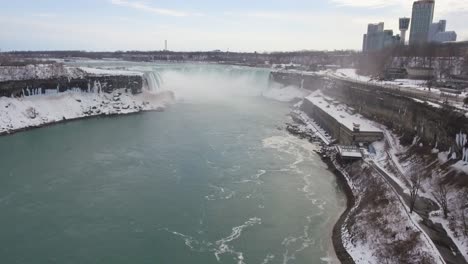 Horseshoe-Falls-at-Niagara-Falls-in-snowy-winter,-wide-aerial-push-in