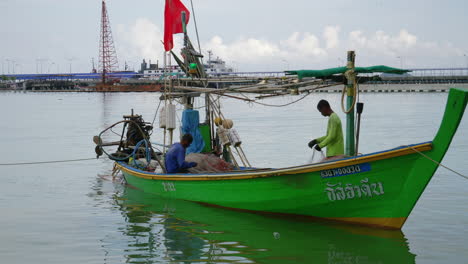 Southeast-asia-fisherman-fix-repair-putaway-net-while-docked-wide-shot
