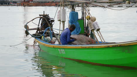 Pescador-Del-Sudeste-Asiático-Repara-Y-Desenreda-La-Red-De-Pesca-En-El-Muelle