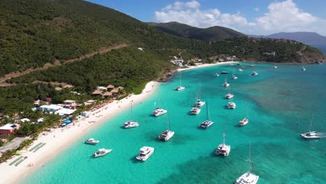 British-Virgin-Islands,-Aerial-View-of-Moored-Boats-and-Catamarans-by-White-Sand-Beach,-Drone-Shot