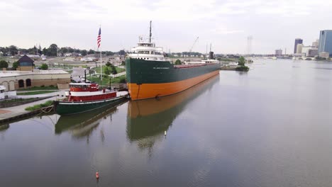 Welle-Der-Amerikanischen-Flagge-In-Der-Nähe-Des-Great-Lakes-Museum-Und-Des-Industrieschiffs,-Luftdrohnenansicht