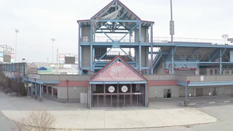 McCoy-Stadium-in-Pawtucket-Rhode-Island,-revealing-drone-staring-on-the-ticket-gate-of-the-abandoned-baseball-field,-aerial