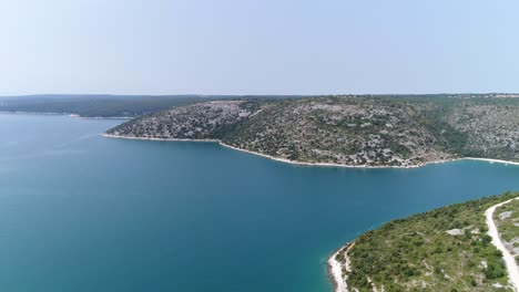 Croatian-Beach-Sea-Coast-of-Pula-Rakalj,-Aerial-Drone-Fly-Above-Idyllic-Bay-of-Pristine-Blue-Water-in-European-Summer,-Travel-and-Tourism