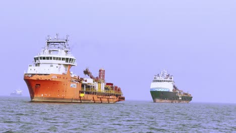 Eine-Seitliche-Aufnahme-Von-Zwei-Frachtschiffen,-Die-Am-Meer-Entlangfahren