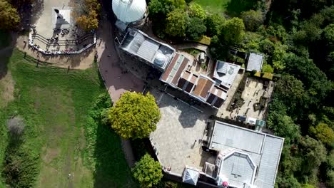 spinning-topview-aerial-of-the-sun-lit-Greenwich-Royal-Observatory-building,-Greenwich,-United-Kingdom