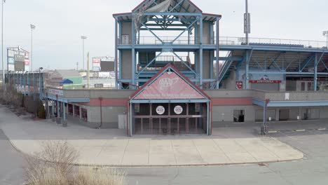Estadio-Mccoy-En-Pawtucket-Rhode-Island,-Revelando-Un-Dron-Que-Comienza-En-La-Entrada-Del-Campo-De-Béisbol-Abandonado,-Antena
