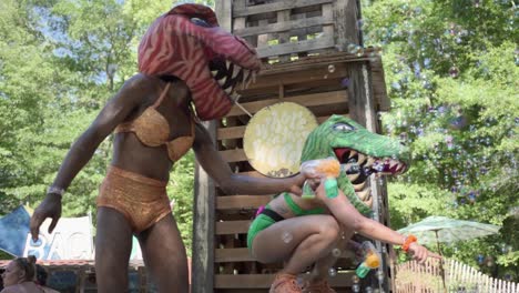 Performers-with-dinosaur-head-performing-and-blowing-baubles