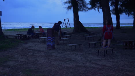 Gente-Preparando-Mesas-De-Picnic-En-La-Playa-Por-La-Noche,-Songkhla,-Tailandia