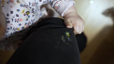 Dirty-Hands-of-Baby-Toddle-Gripping-Parents-Pants,-Conceptual-Shot