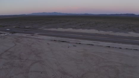 Dry-lake-bed-Nevada-at-sunset-aerial-pullback-rising-reveals-stunning-mountians