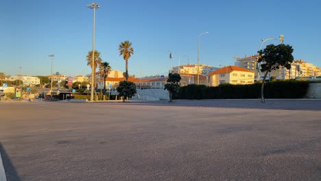 Empty-beach-car-park-spaces-covered-in-asphalt-with-some-palm-trees-in-Estoril