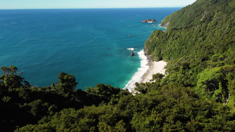 Beauty-of-New-Zealand-west-coast-with-high-cliffs-overgrown-in-forest,-aerial-view