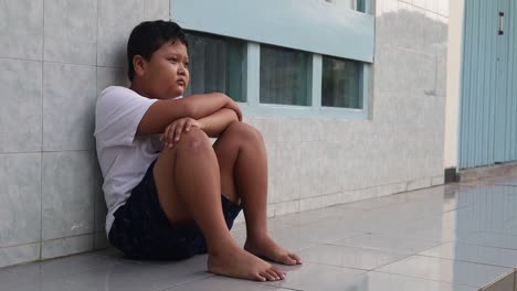 Depressed-boy-sitting-on-the-terrace-floor