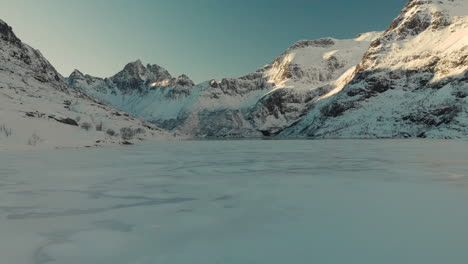 Drone-shot-of-a-frozen-lake-in-lofoten-with-mountains-in-the-background