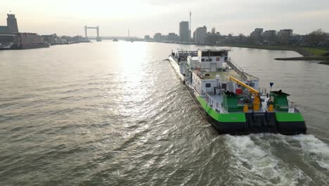 Aerial-view-over-cargo-vessel-gliding-through-water-channel-in-Dordrecht,-Netherlands
