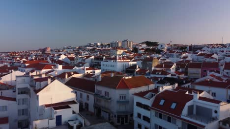 Drone-Flyover-residential-buildings-in-Ericeira-Village,-Portuguese-Coastline