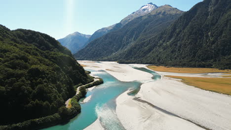Idyllic-landscape-of-Haast-river-valley-surrounded-by-lush-forest,-New-Zealand