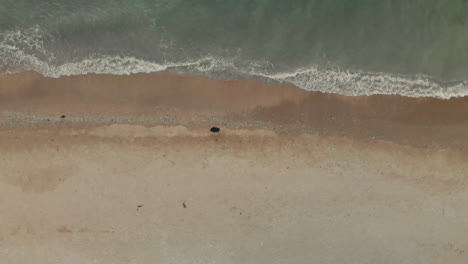 Drone-shot-of-a-men-standing-in-front-of-the-sea